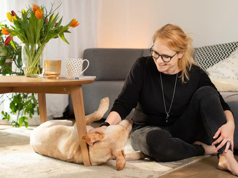 Donna che accarezza il cane in un appartamento